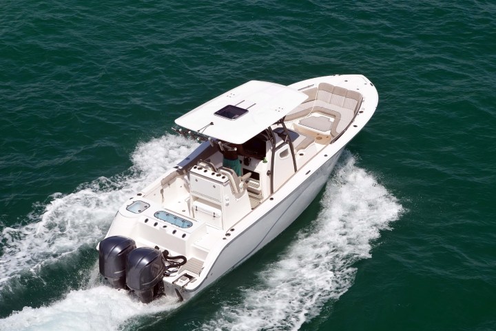 Aerial view of a motorboat with two engines speeding on blue water.