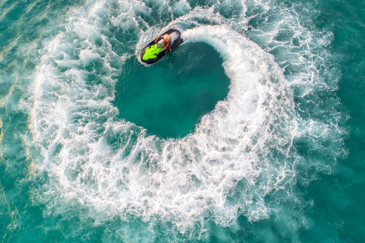 Person on a jet ski making a circular pattern in turquoise water.