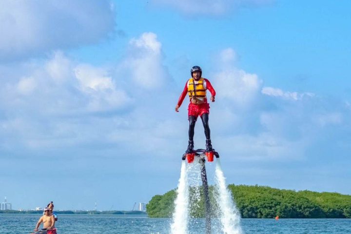 a man riding on the back of a boat in a body of water